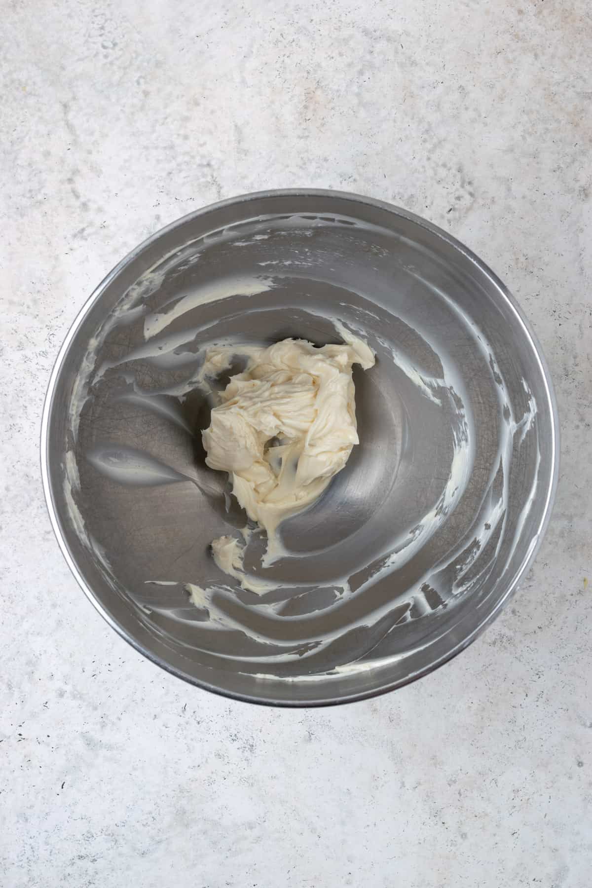 Creamed butter in a large metal mixing bowl.