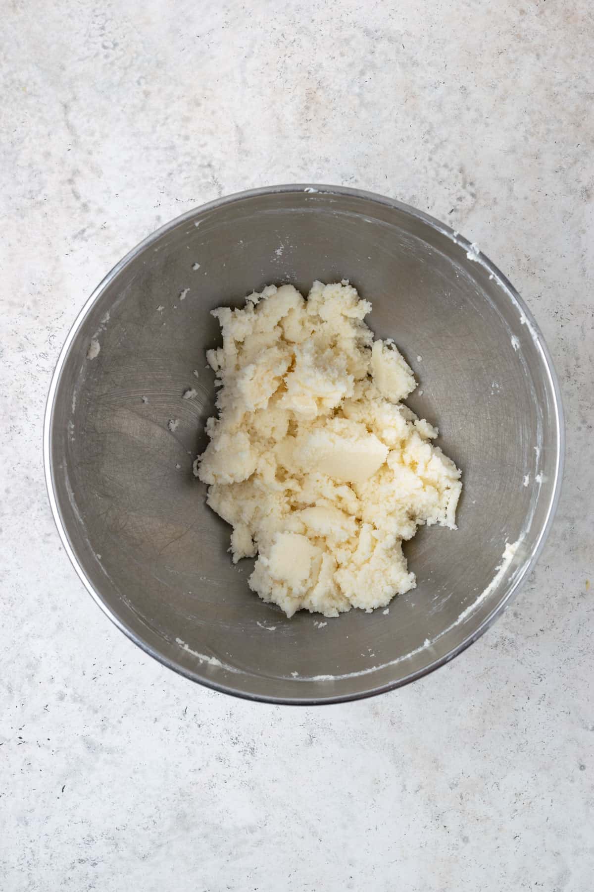 Sugar and butter creamed together in a large metal mixing bowl.