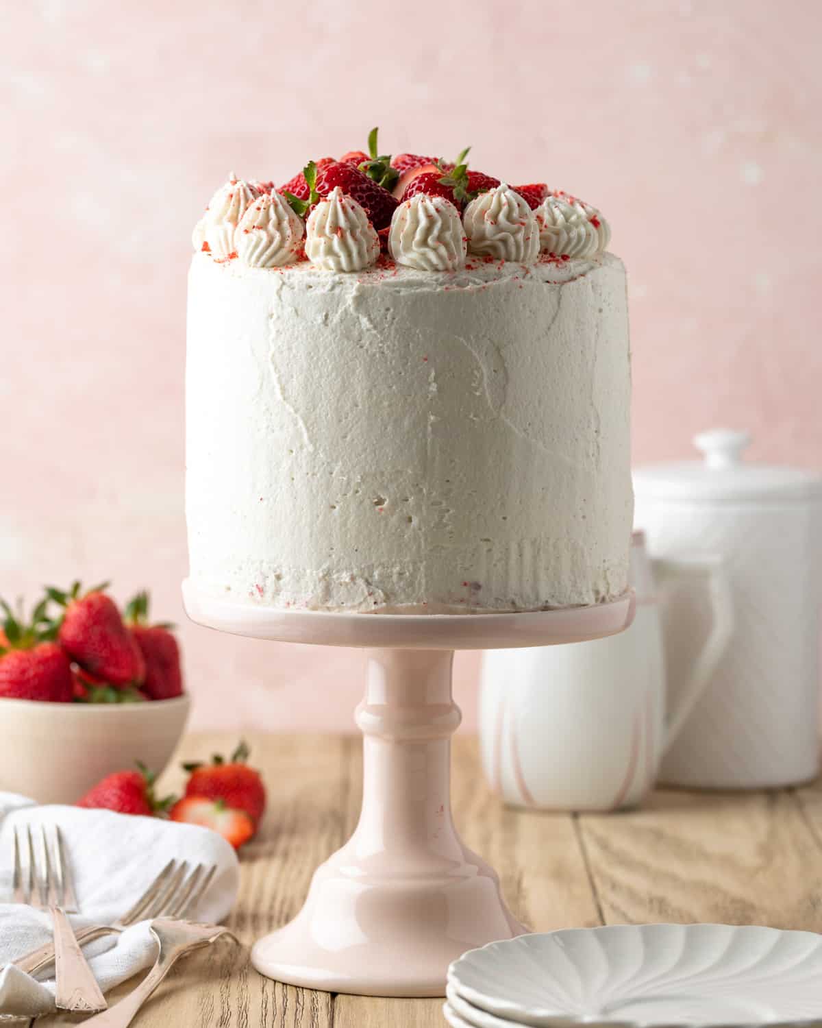 Gluten free strawberry cake covered with cream cheese frosting and fresh strawberries.