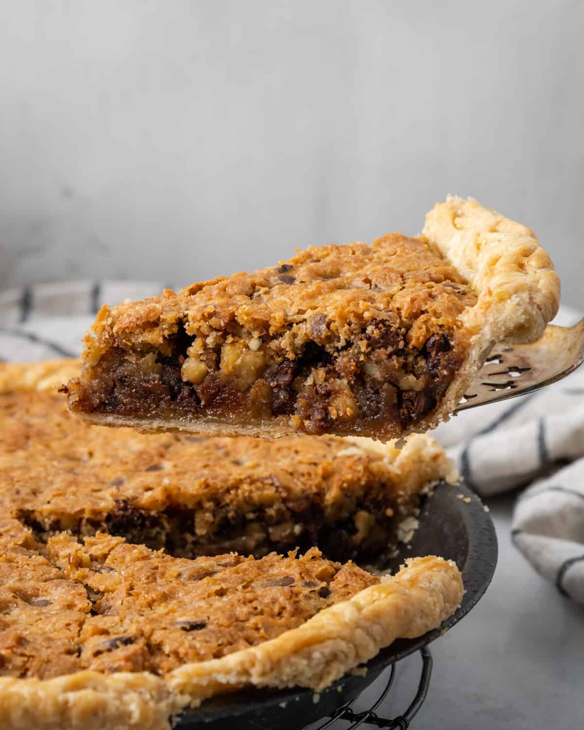 A slice of kentucky derby pie being lifted from a pie plate.