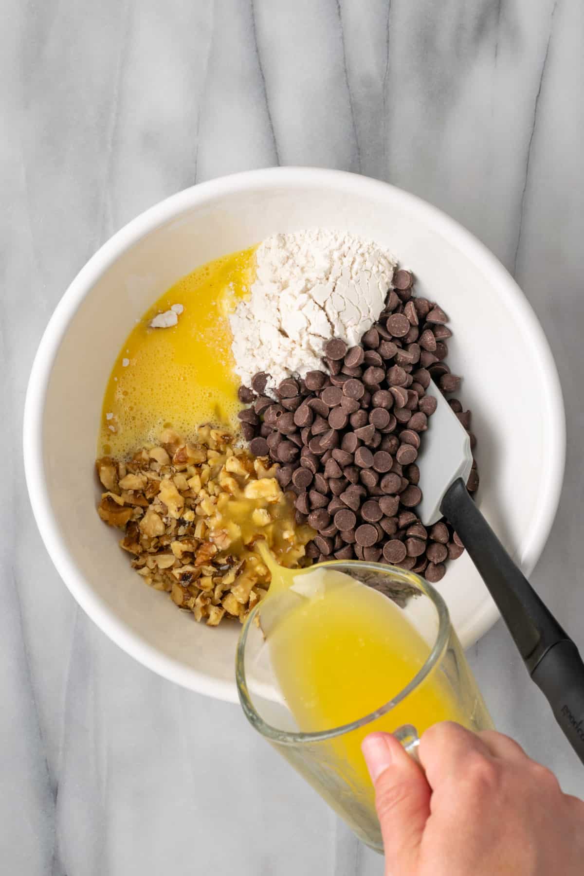 Ingredients for derby pie combined together in a large white bowl.