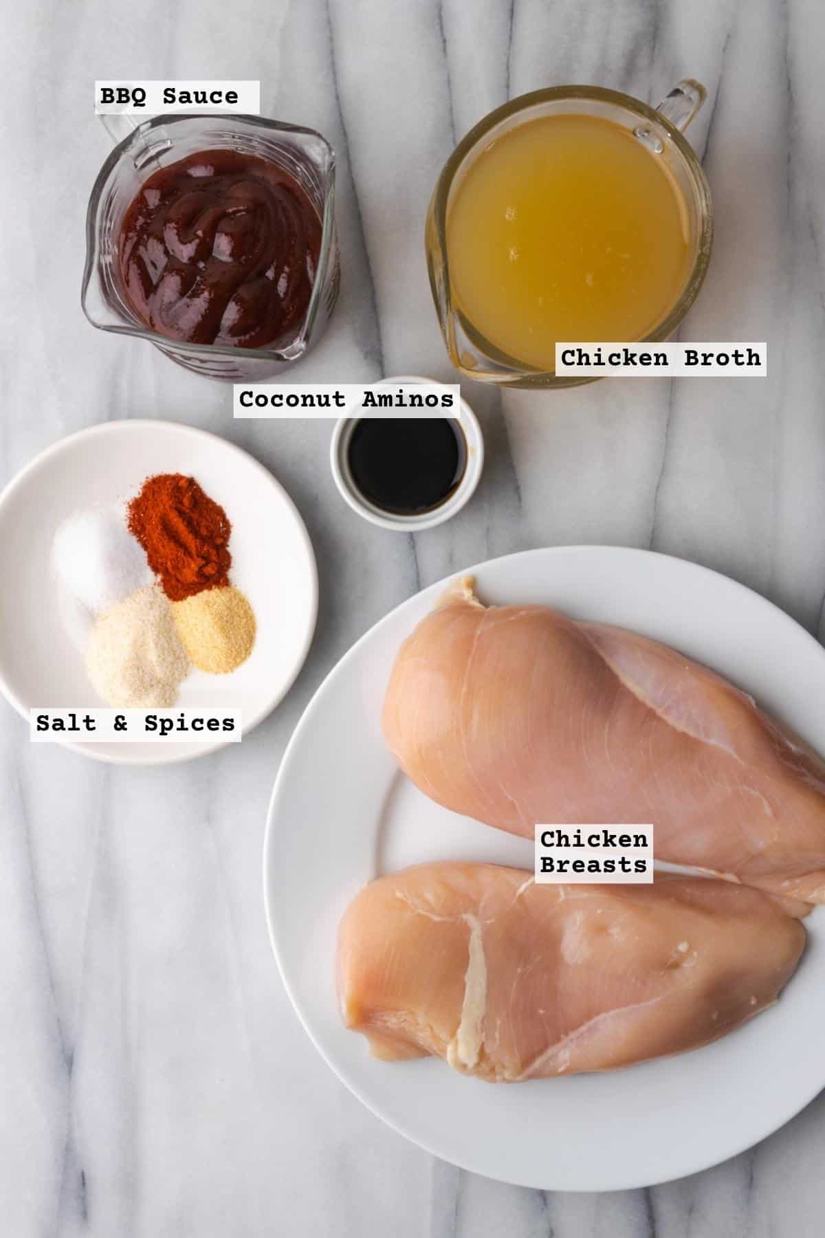 Ingredients for instant pot bbq chicken on a white marble table.