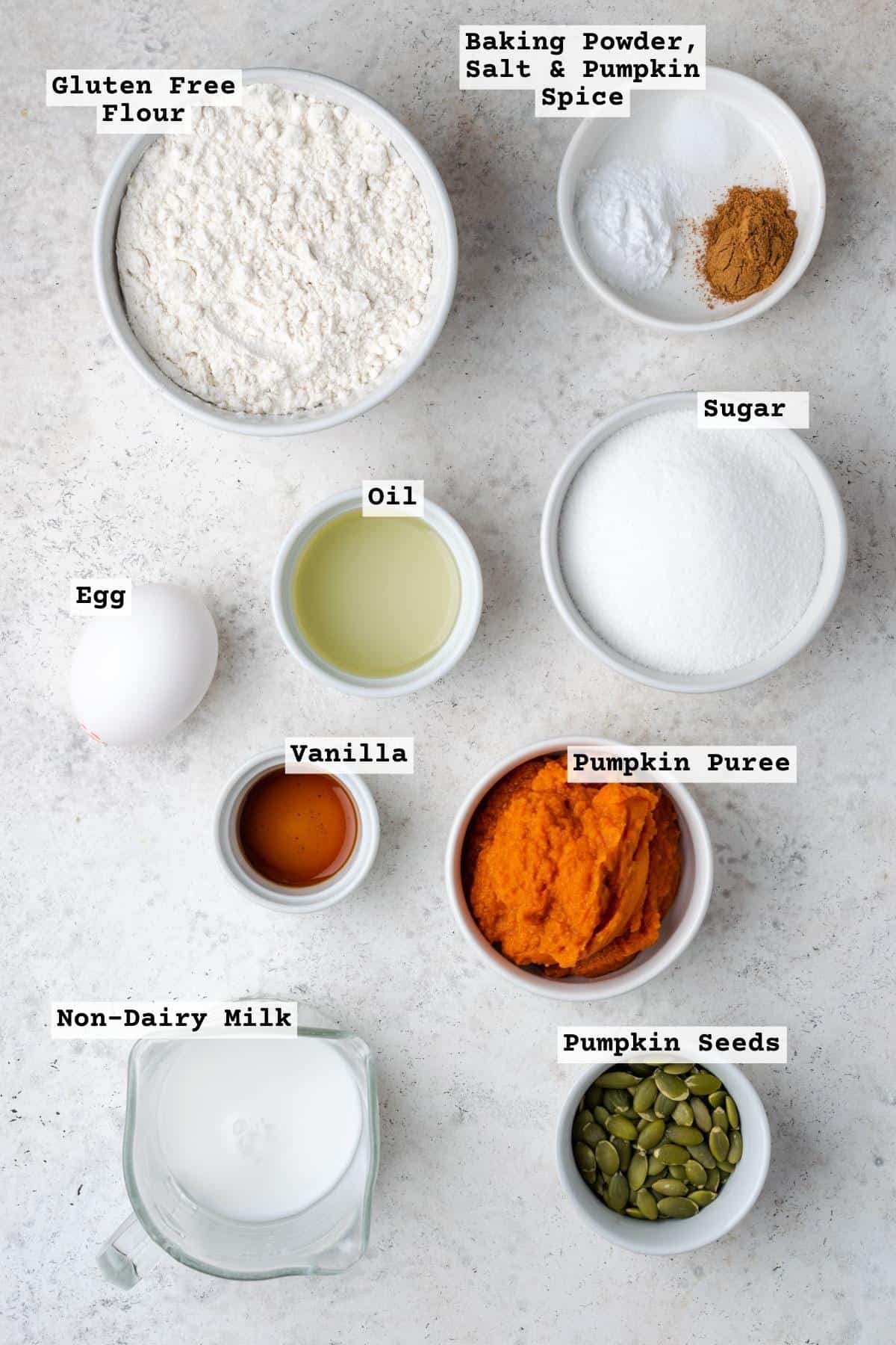 Ingredients for gluten free pumpkin muffins on a white table.