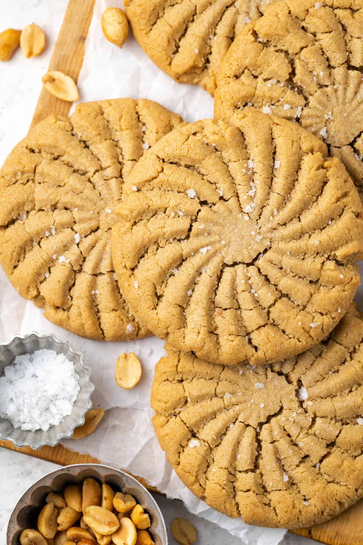 Gluten free peanut butter cookies laying on a wooden cutting board.