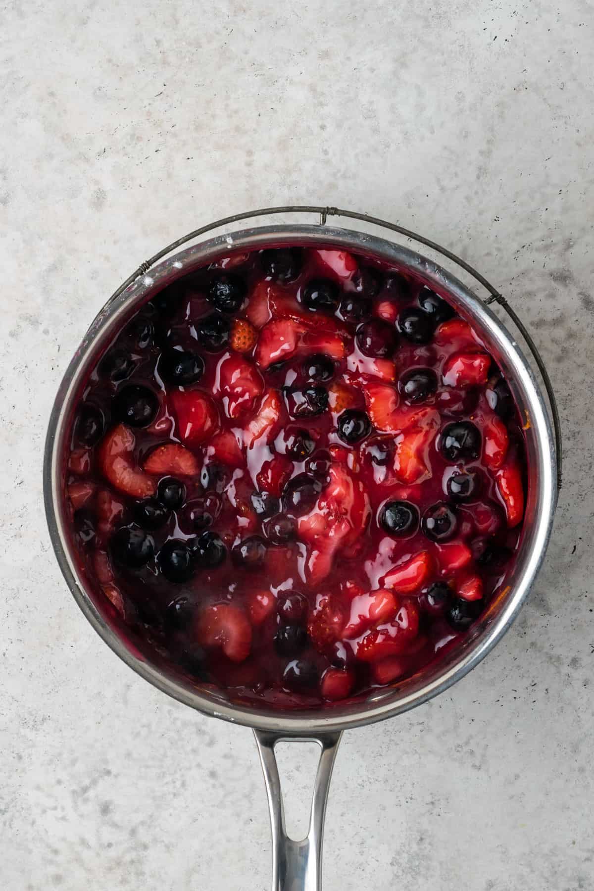 Strawberry blueberry pie filling in a saucepan.