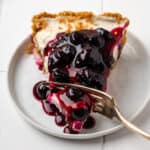 A bite being taken from a slice of no bake blueberry cheesecake.