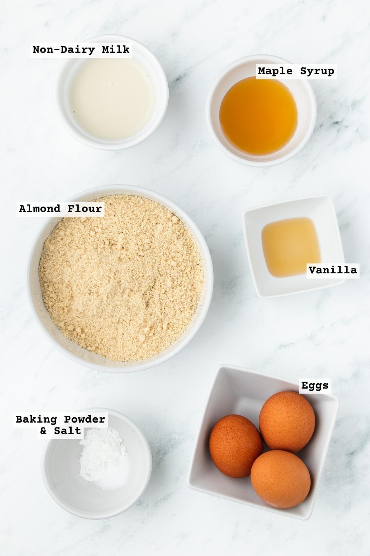 Ingredients for grain free pancakes made with almond flour on a white table.