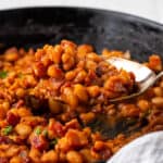A spoon scooped out a helping of gluten free baked beans.