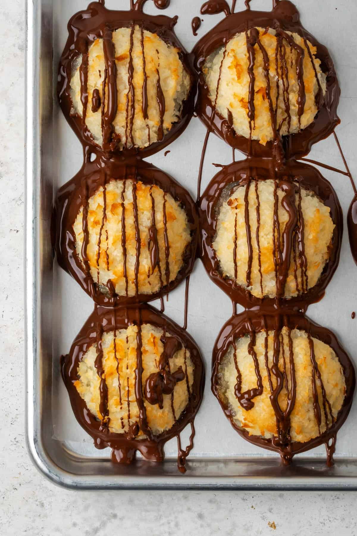 Golden brown coconut macaroons covered with melted chocolate.