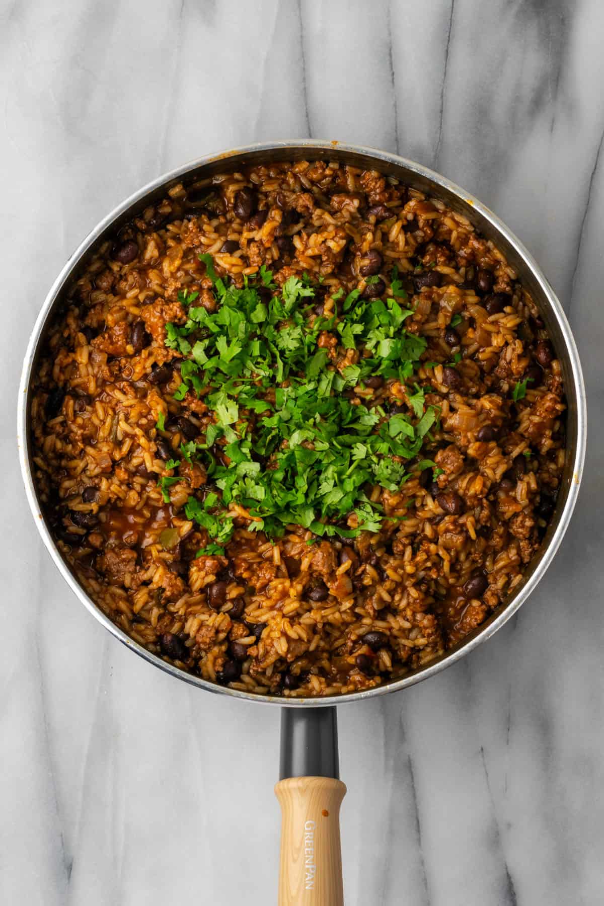 Chopped cilantro added to the cooked beef and rice skillet.