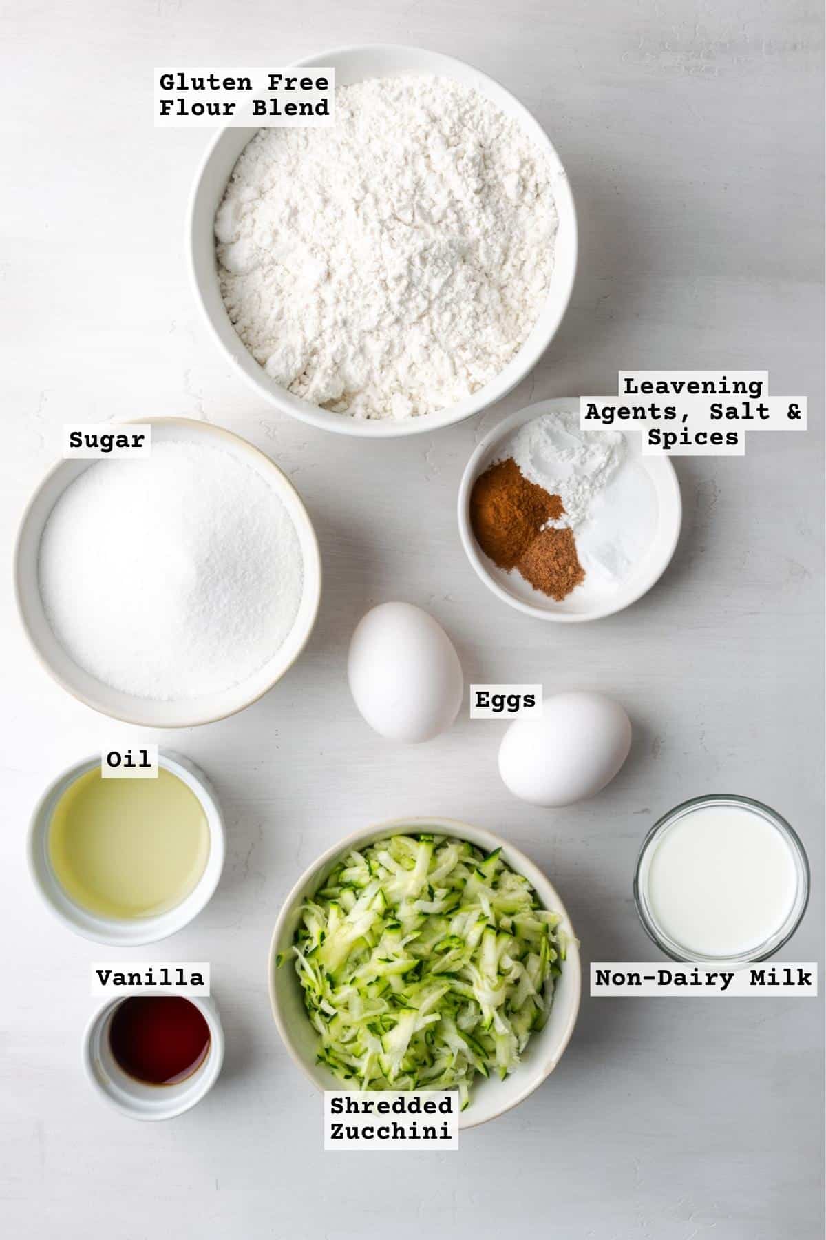 Ingredients for gluten free zucchini bread on a white table. 