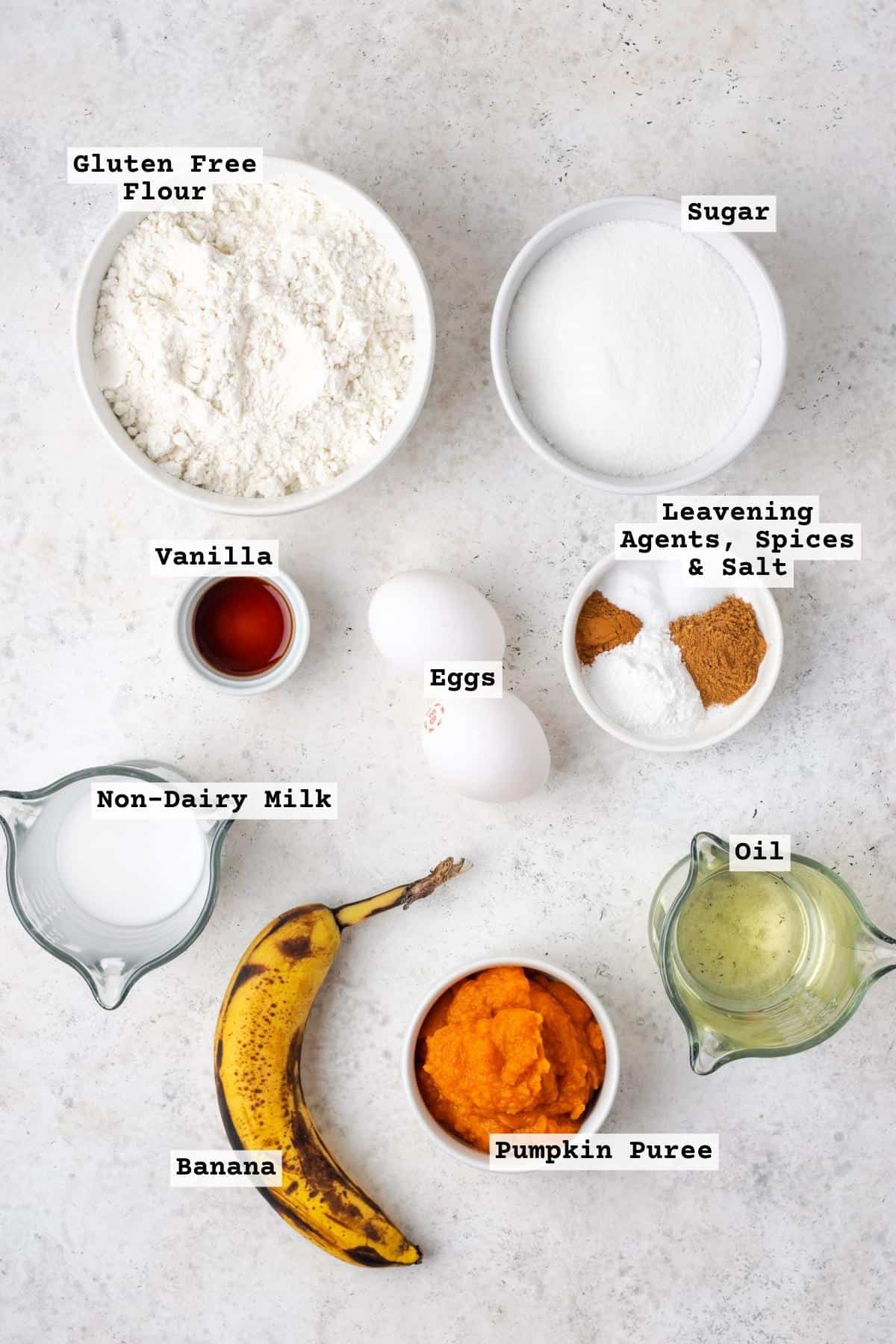 Ingredients for pumpkin banana bread on a white table.