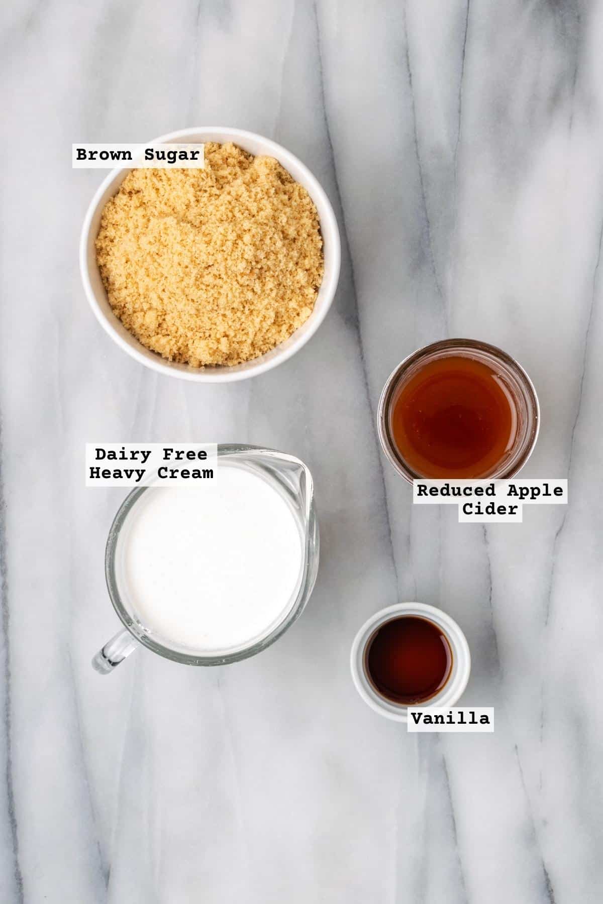 Ingredients for apple cider caramel on a white marble table.