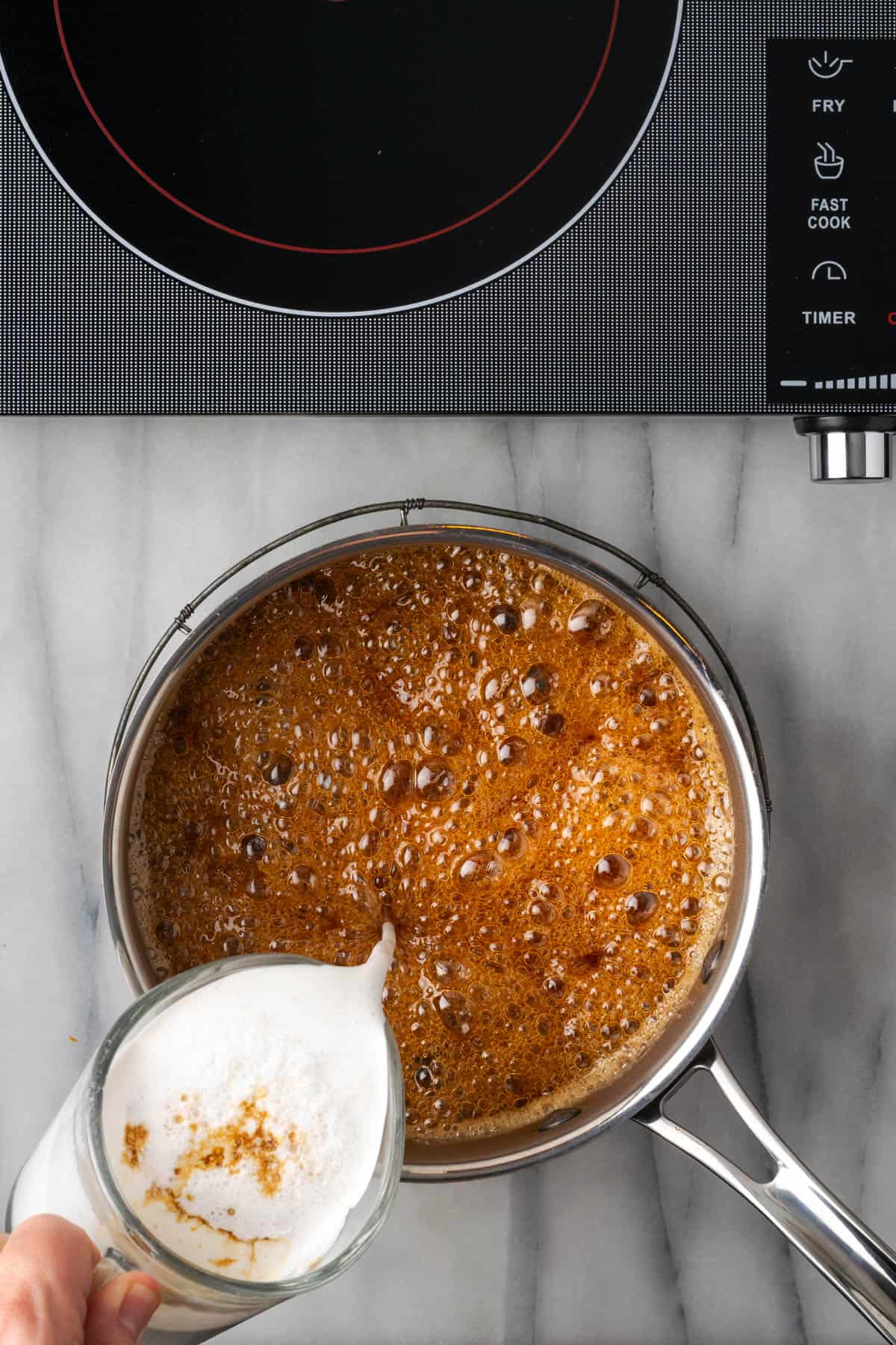 Cream being poured into the hot sugar mixture.