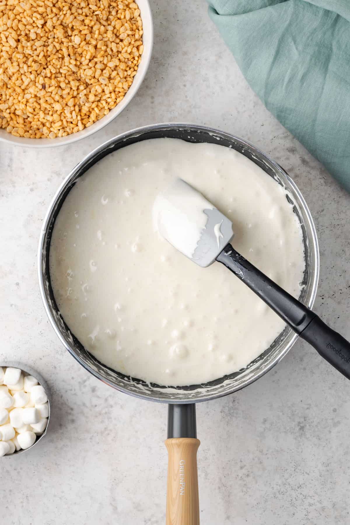 Melted marshmallow being stirred in a large saucepan.