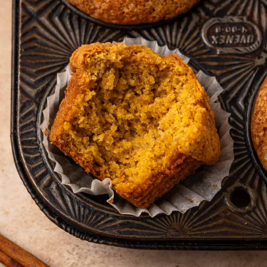 A pumpkin banana muffin with a bite taken out.