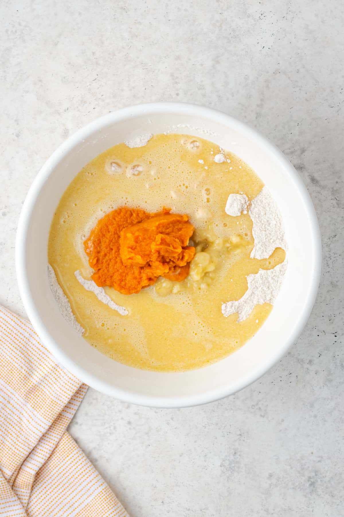 Wet ingredients, mashed banana and pumpkin puree all added to the dry ingredients in a large mixing bowl. 