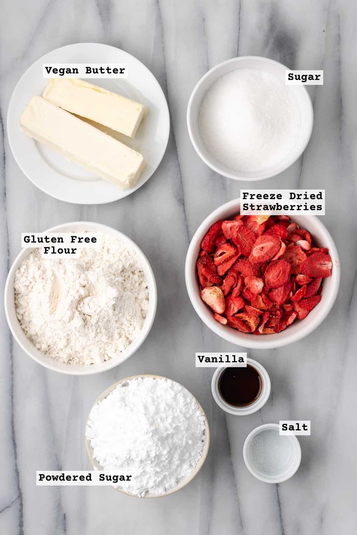 Ingredients for strawberry shortbread cookies on a white table.