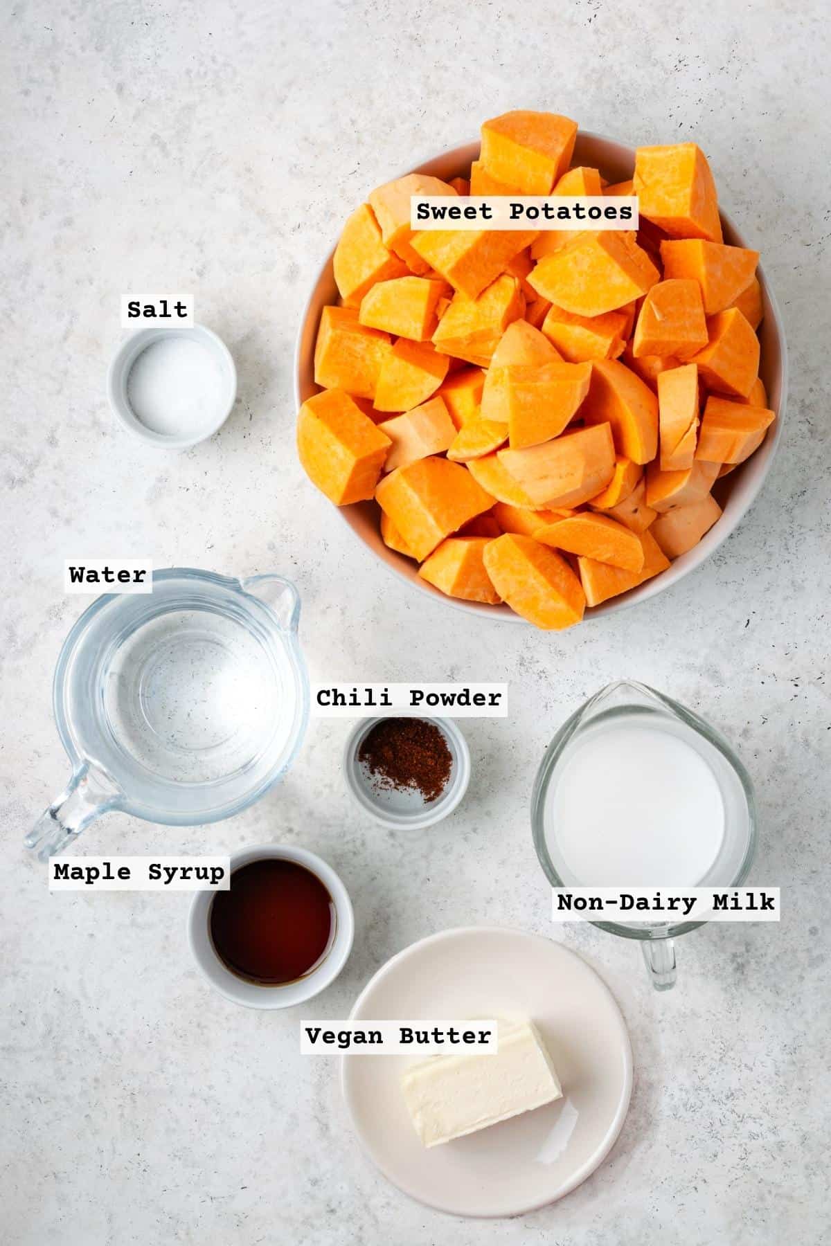 Ingredients for mashed sweet potatoes on a white table.