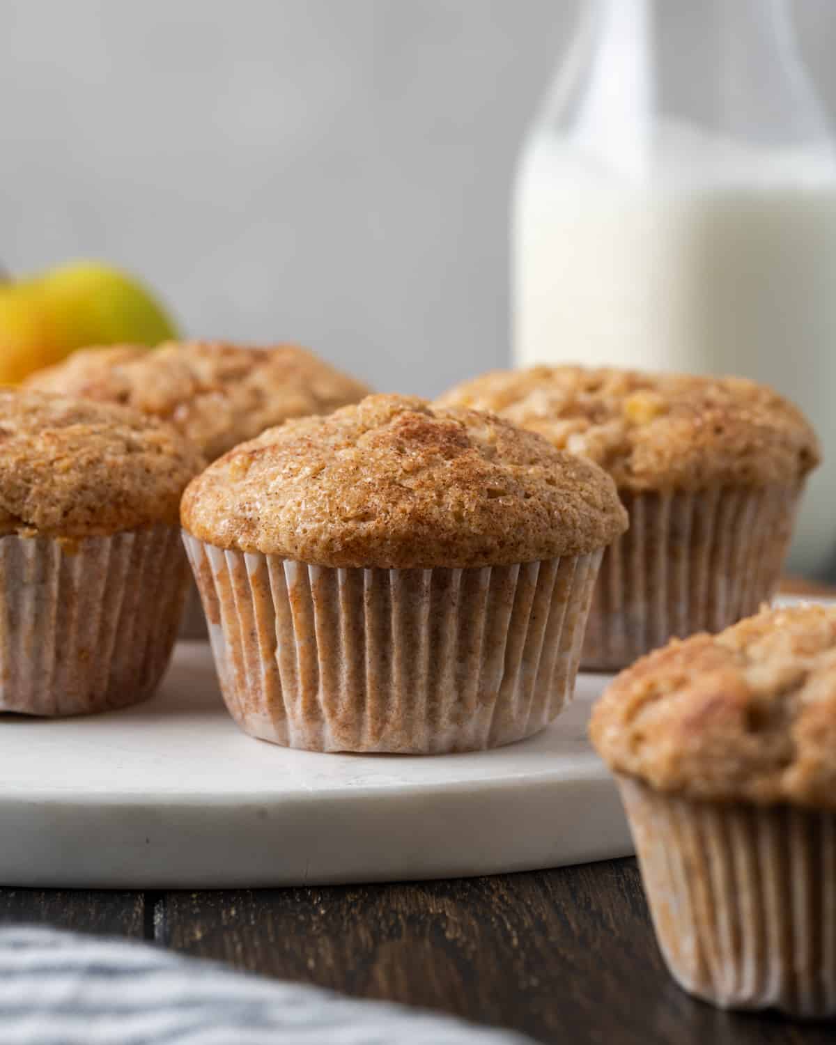 Apple banana muffins sitting on a marble cutting board.