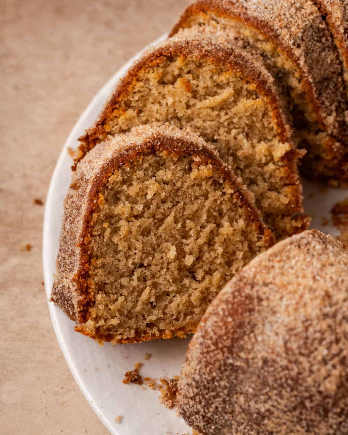 A sliced apple cider donut cake on a white plate.