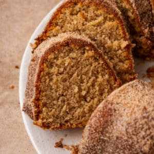 A sliced apple cider donut cake on a white plate.