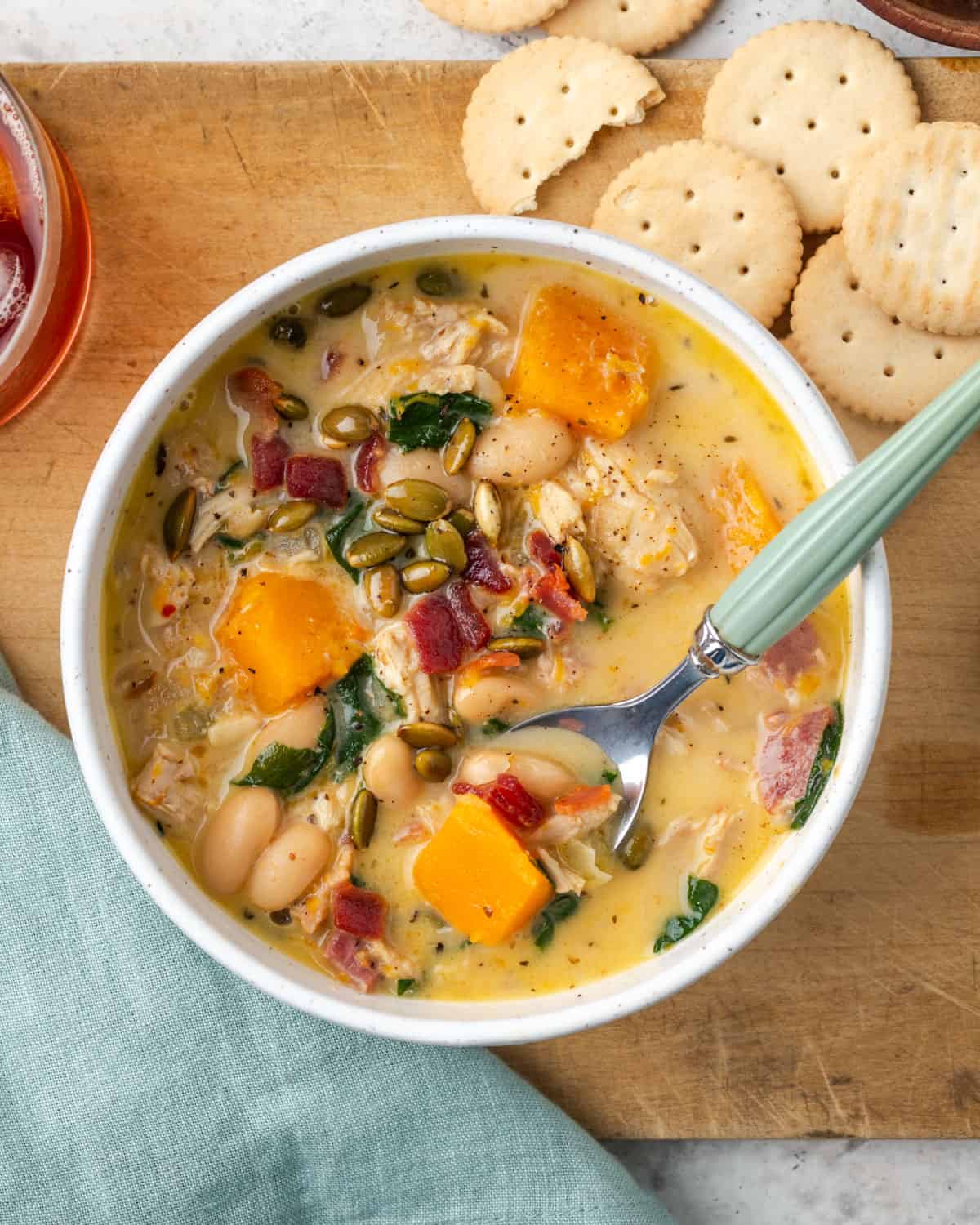 A bowl of chicken butternut squash soup served with crackers. 