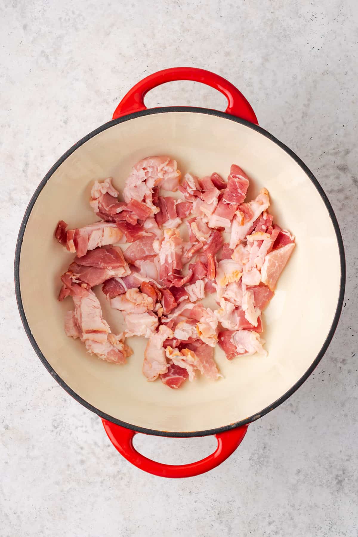 Bacon cooking in a large dutch oven pot.