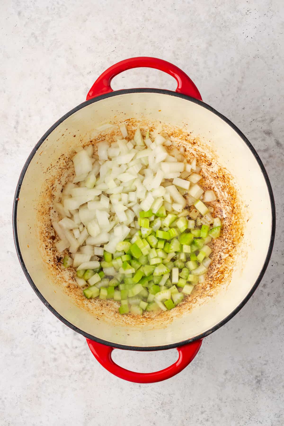 Diced onion and celery cooking in a soup pot.