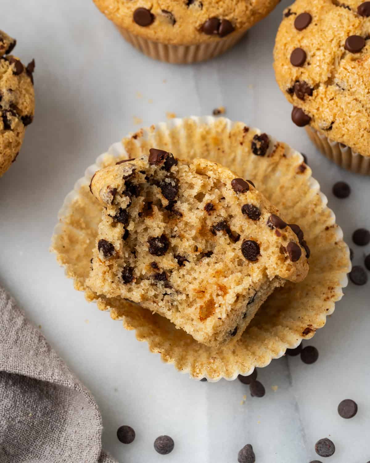 A chocolate chip muffin with a bite taken out.