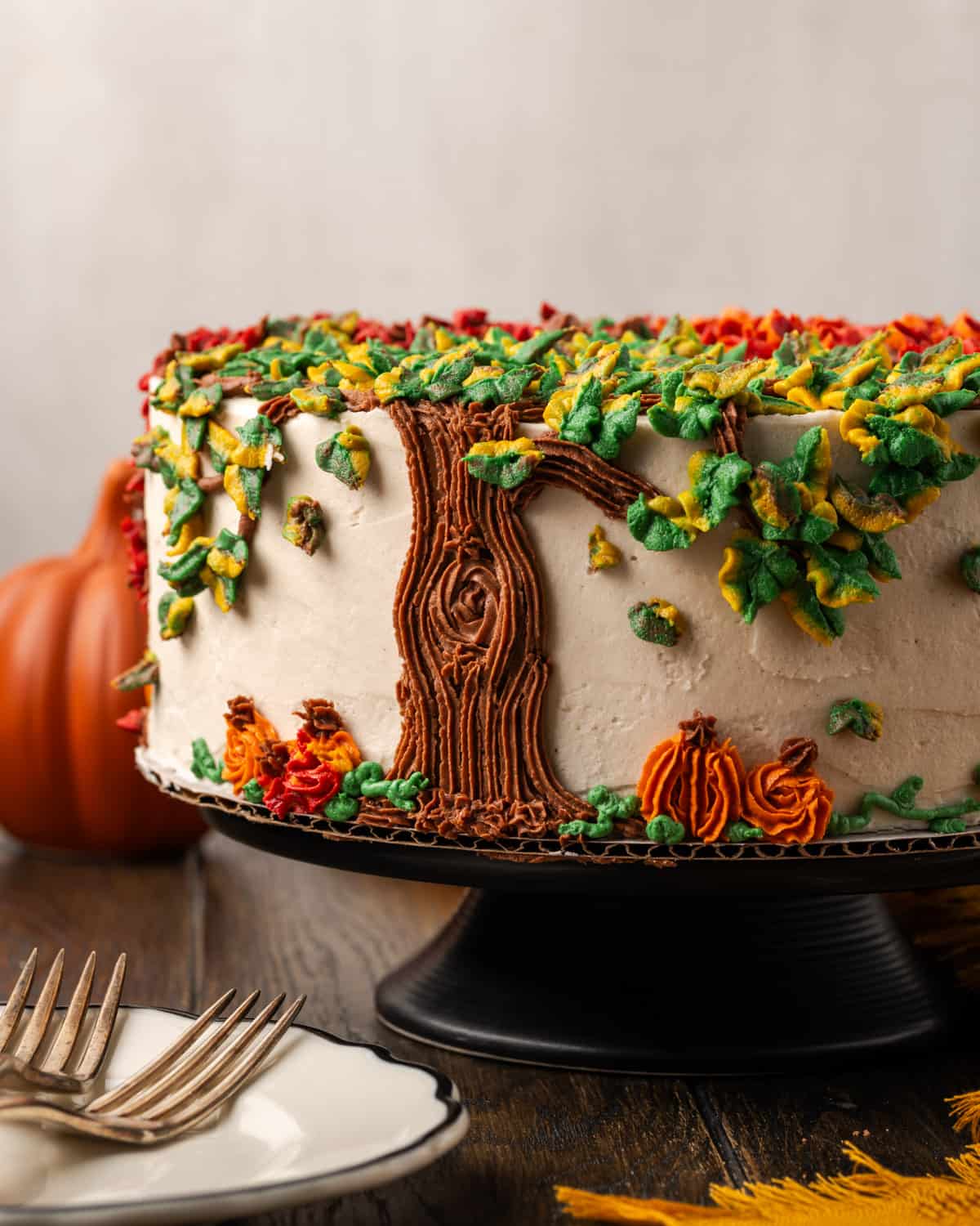 A gluten free pumpkin cake sitting on a black cake stand.