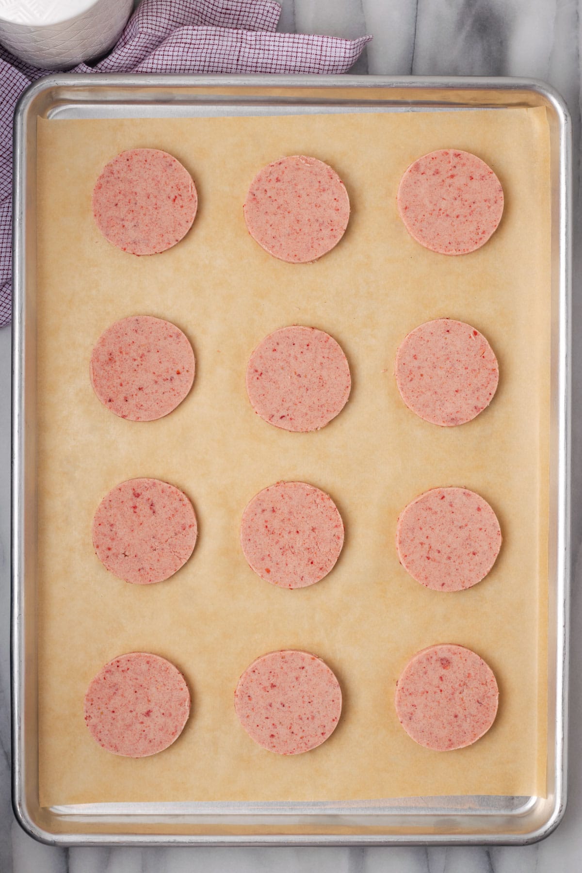 Twelve unbaked shortbread cookies on a baking sheet.