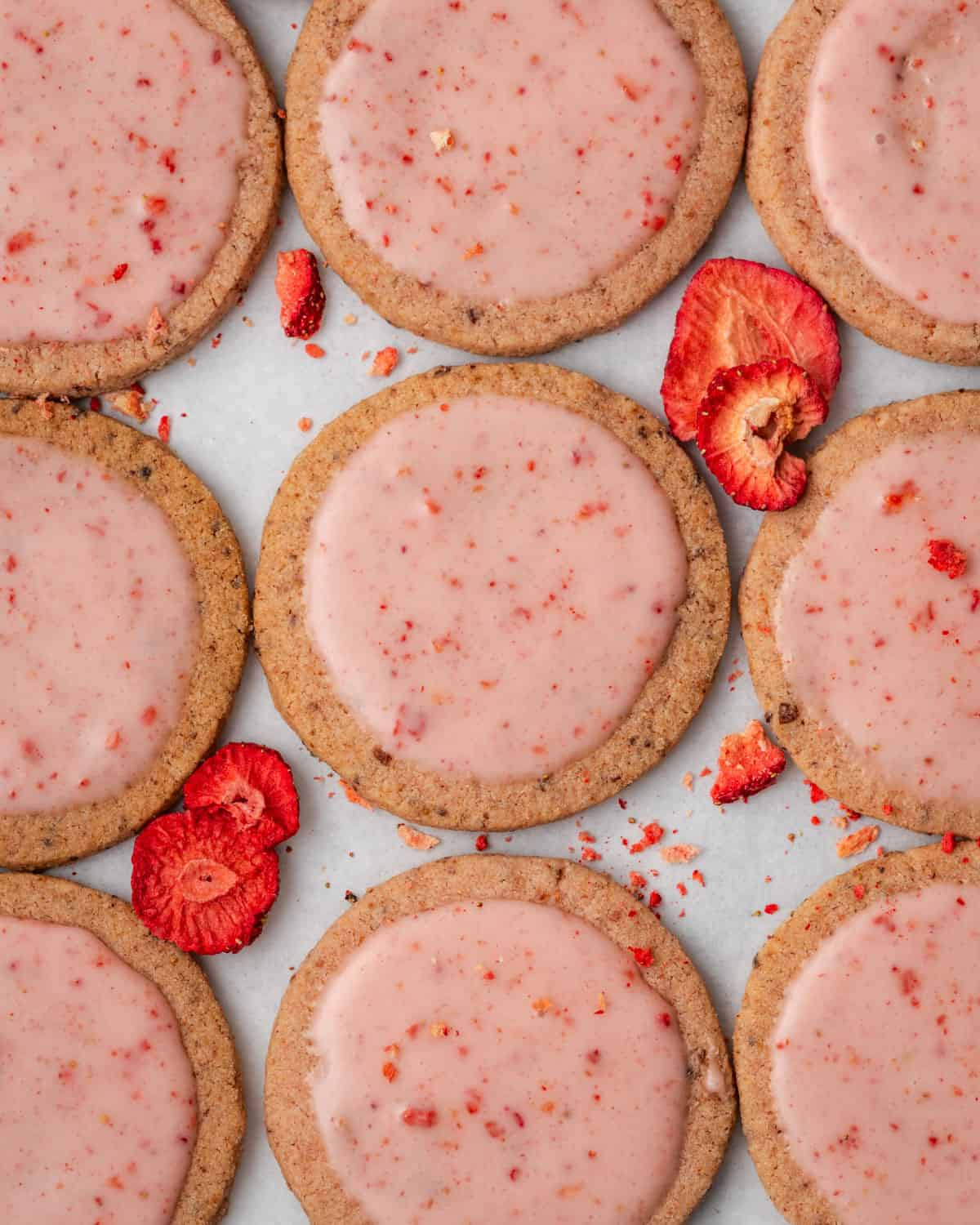 Strawberry shortbread cookies lined up on a baking sheet.