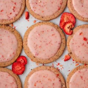 Strawberry shortbread cookies lined up on a baking sheet.