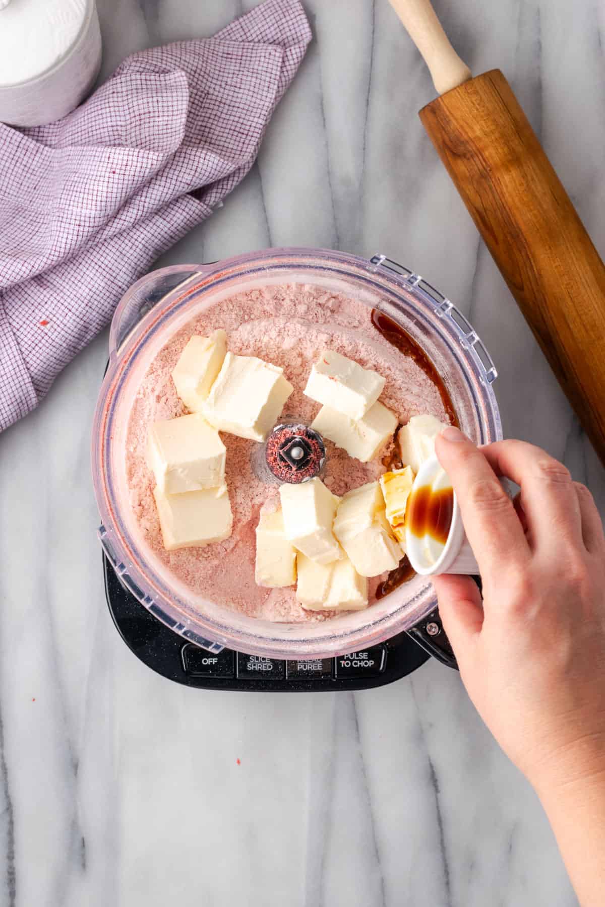 Butter and vanilla being added to the food processor. 