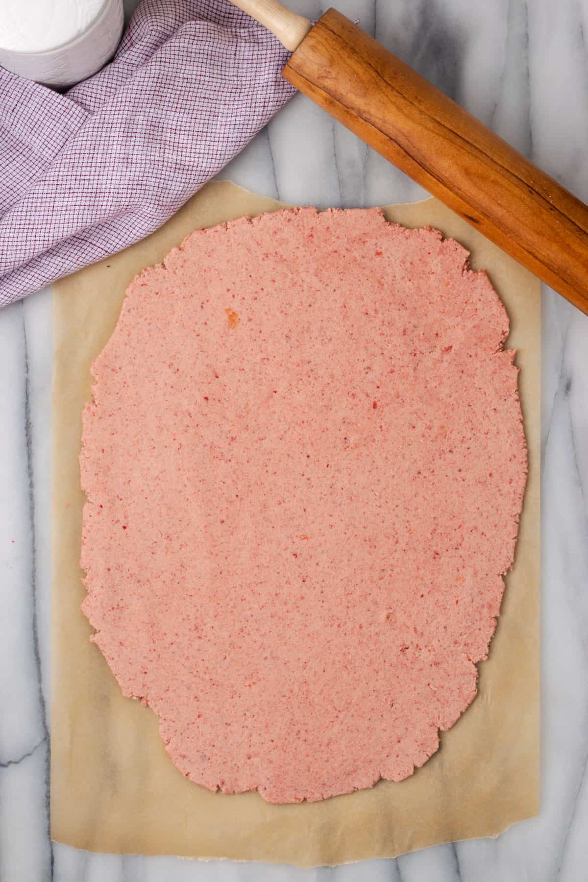 Pink shortbread dough rolled out into a sheet. 