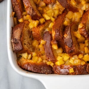 A pan of brioche baked french toast topped with apple pie filling.