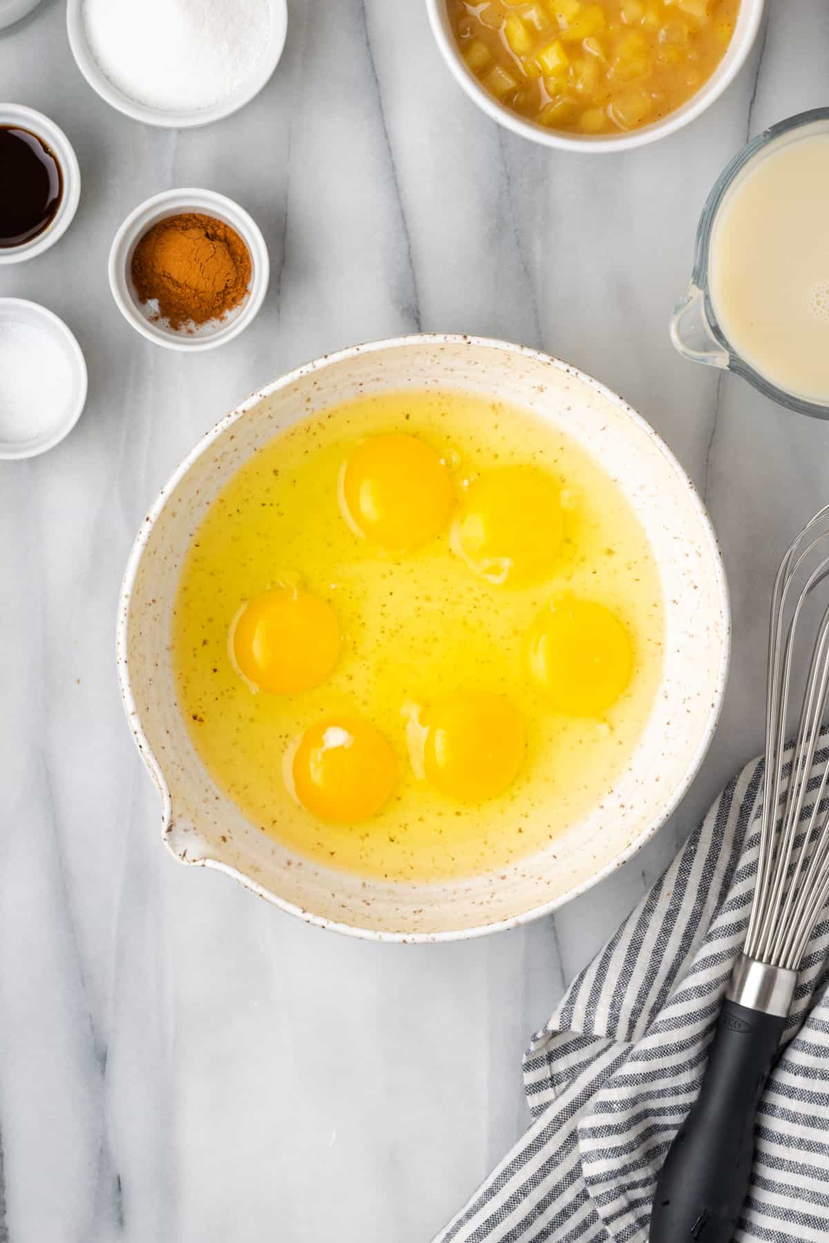 Six eggs in a large white mixing bowl.