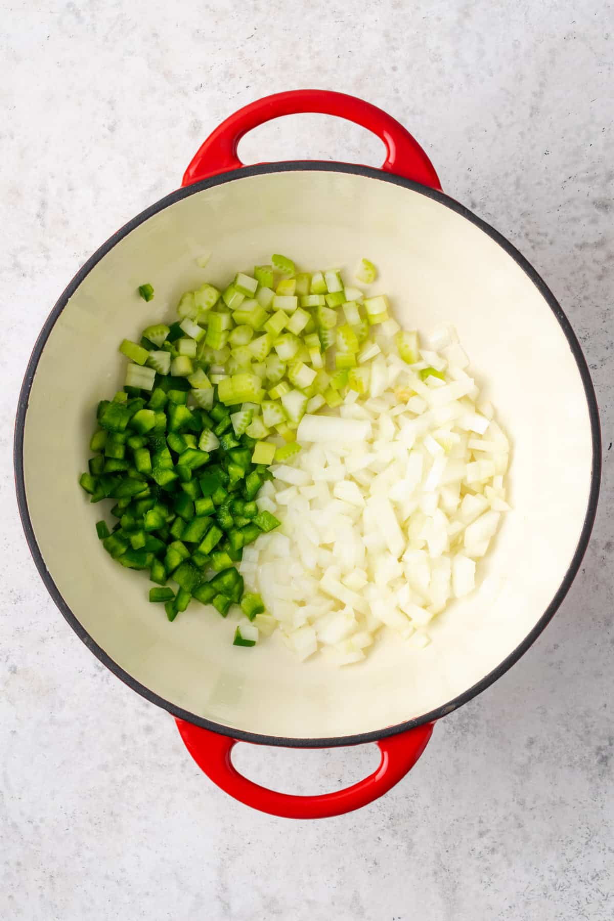 Onion, green bell pepper and celery cooking in a large soup pot.