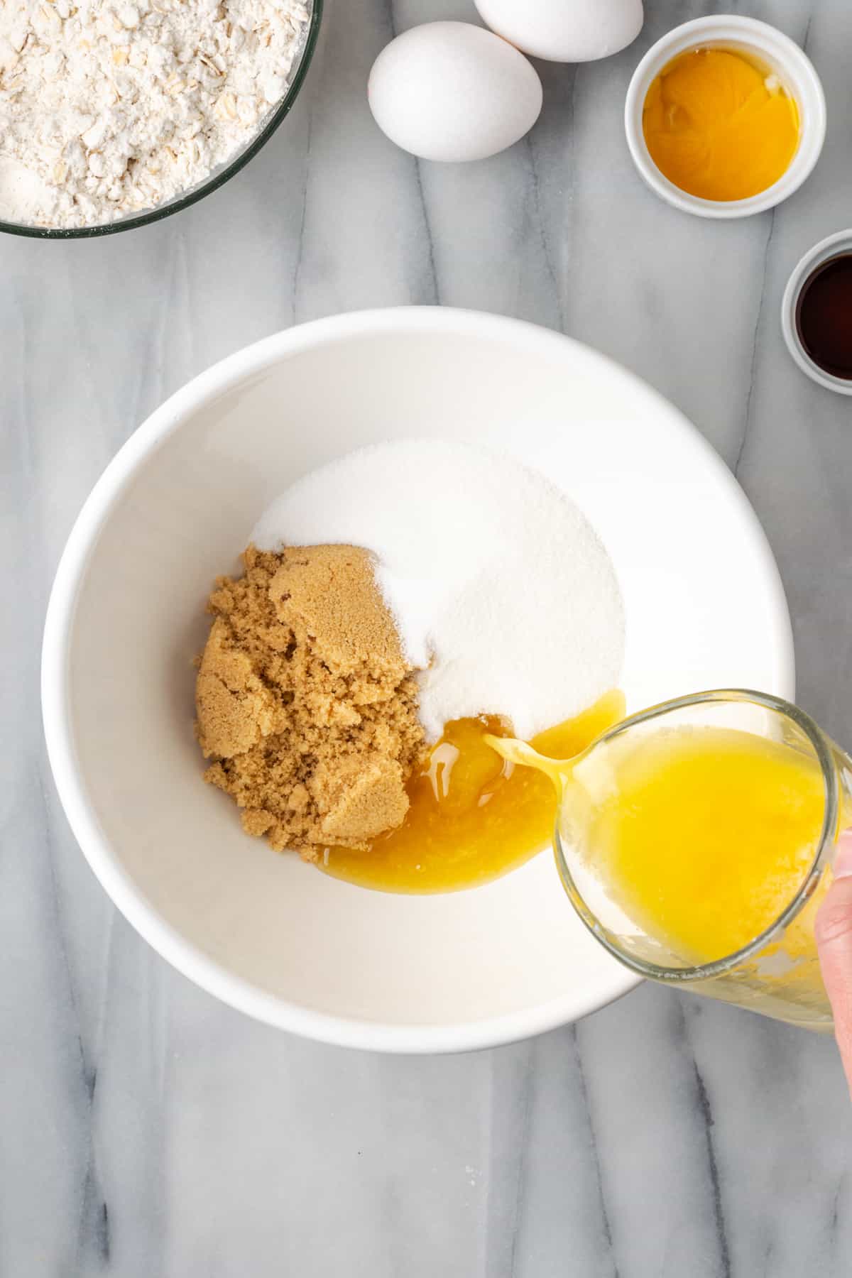 Brown sugar, white sugar and melted butter combined in a large mixing bowl.