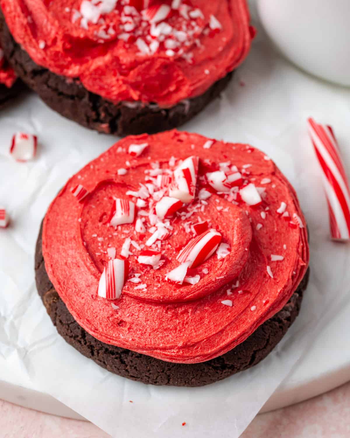 A double chocolate cookie topped with red peppermint frosting and crushed candy cane pieces.