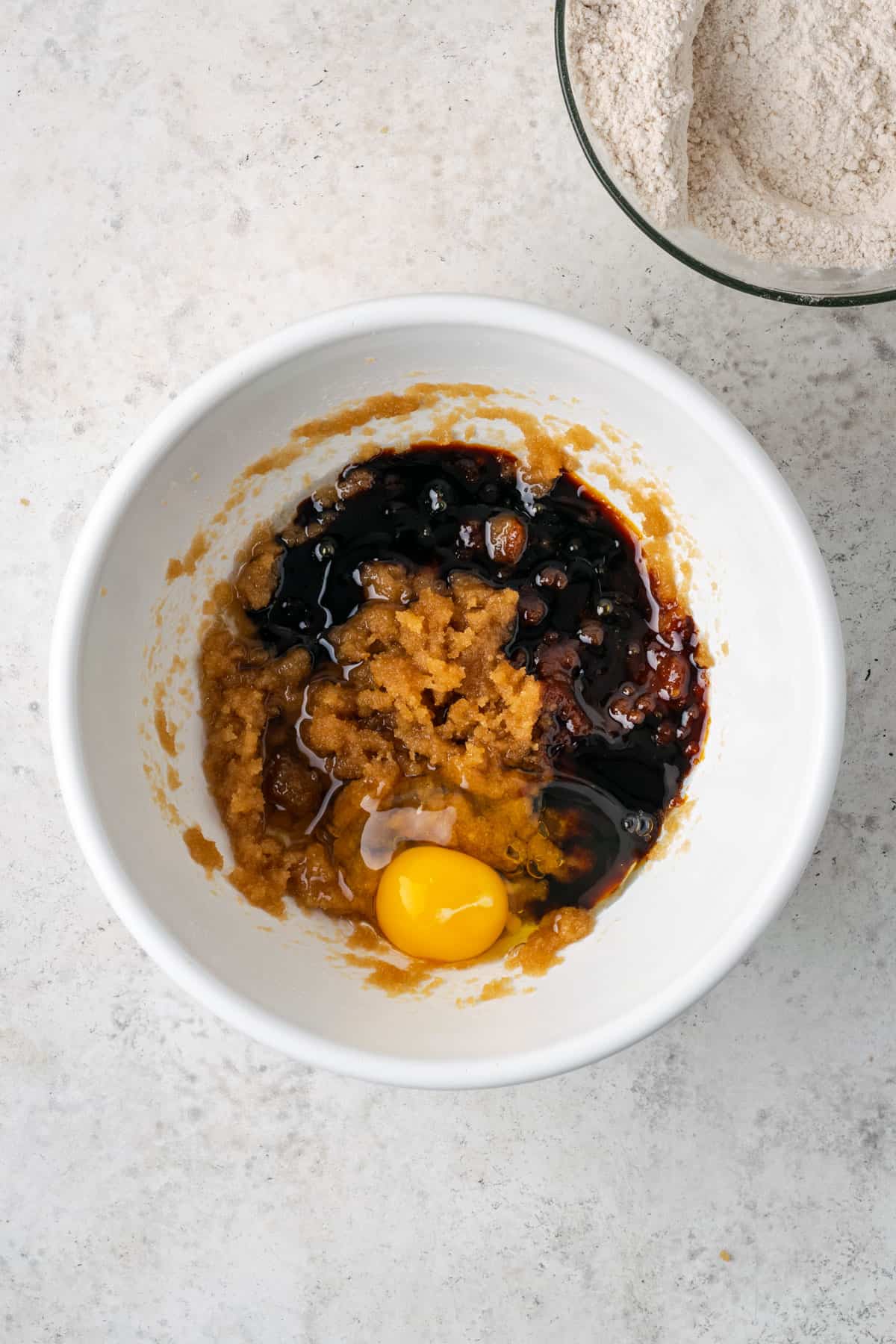 A single egg and molasses added to the bowl with the brown sugar and oil.