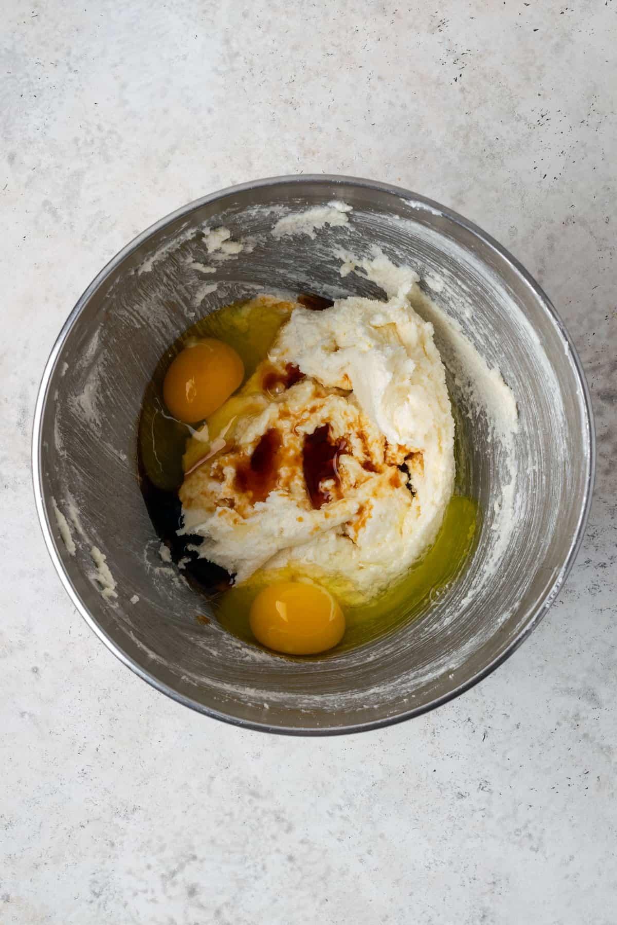 Two eggs and vanilla added to the creamed butter and sugar in a large metal mixing bowl. 