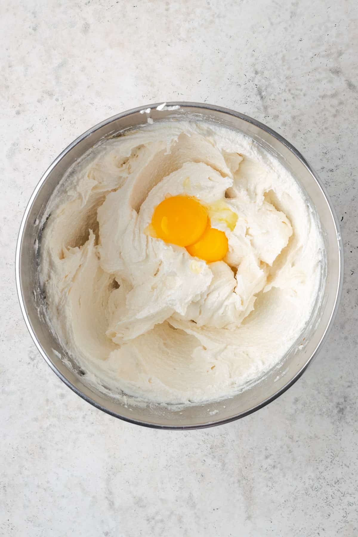 Egg yolks added to the mixing bowl with the partially mixed cake batter.