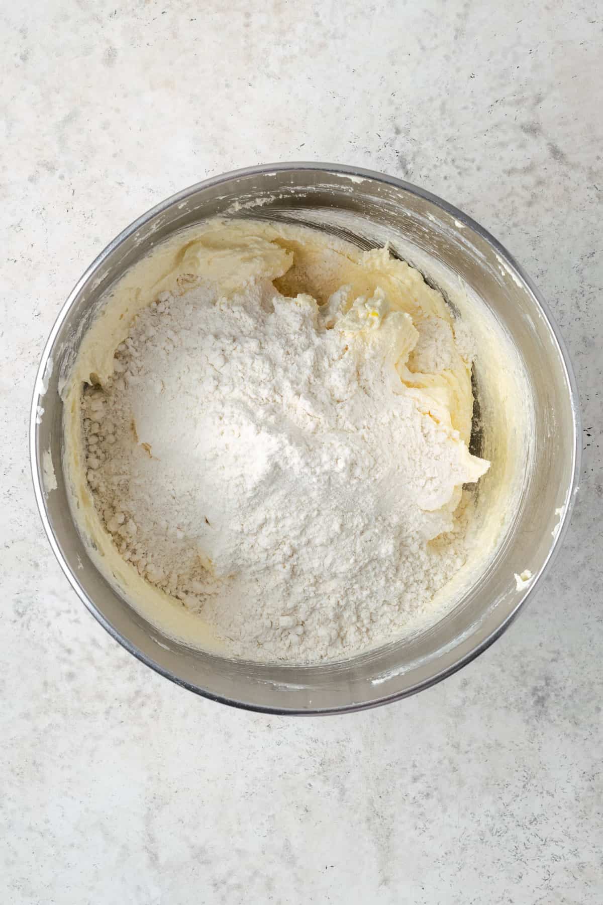 Dry ingredients being added to the mixing bowl with the cake batter.