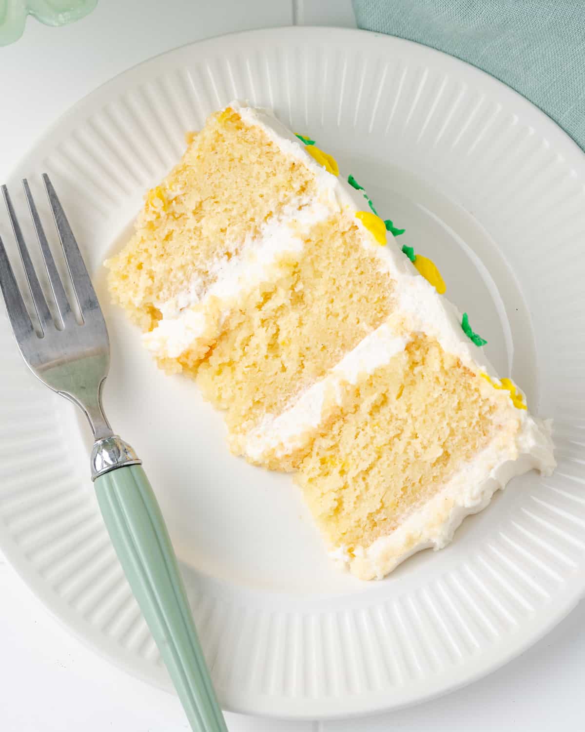 A slice of gluten free lemon cake served on a white plate.