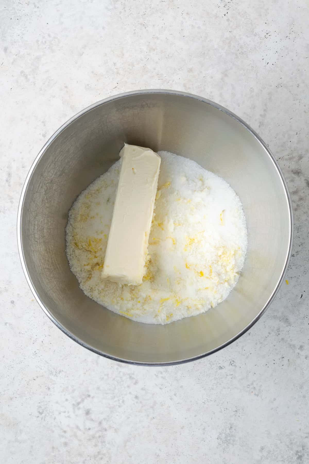 Butter, sugar and lemon zest combined in a large metal mixing bowl. 