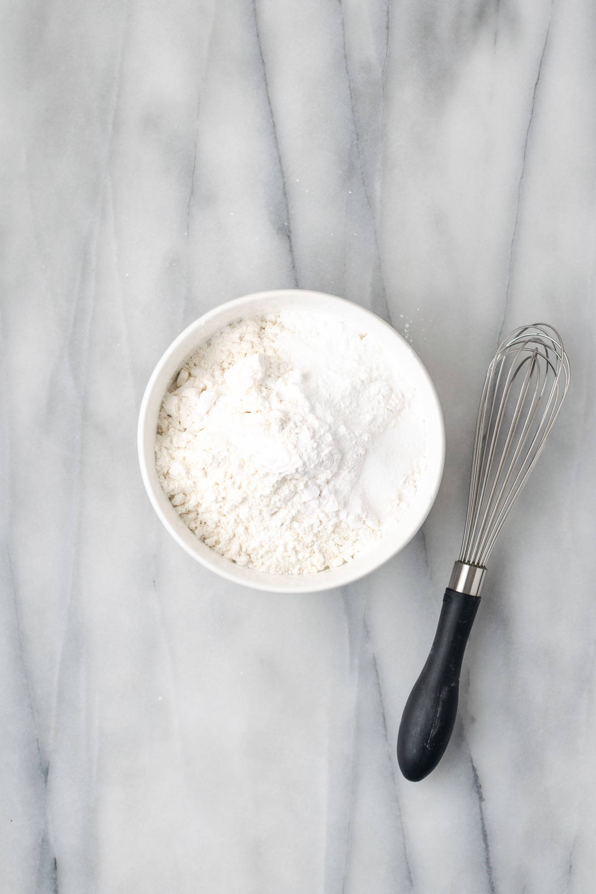 Gluten free flour, cornstarch, baking powder and salt combined in a small white bowl. 