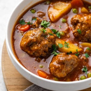 Meatball stew served in a white bowl.