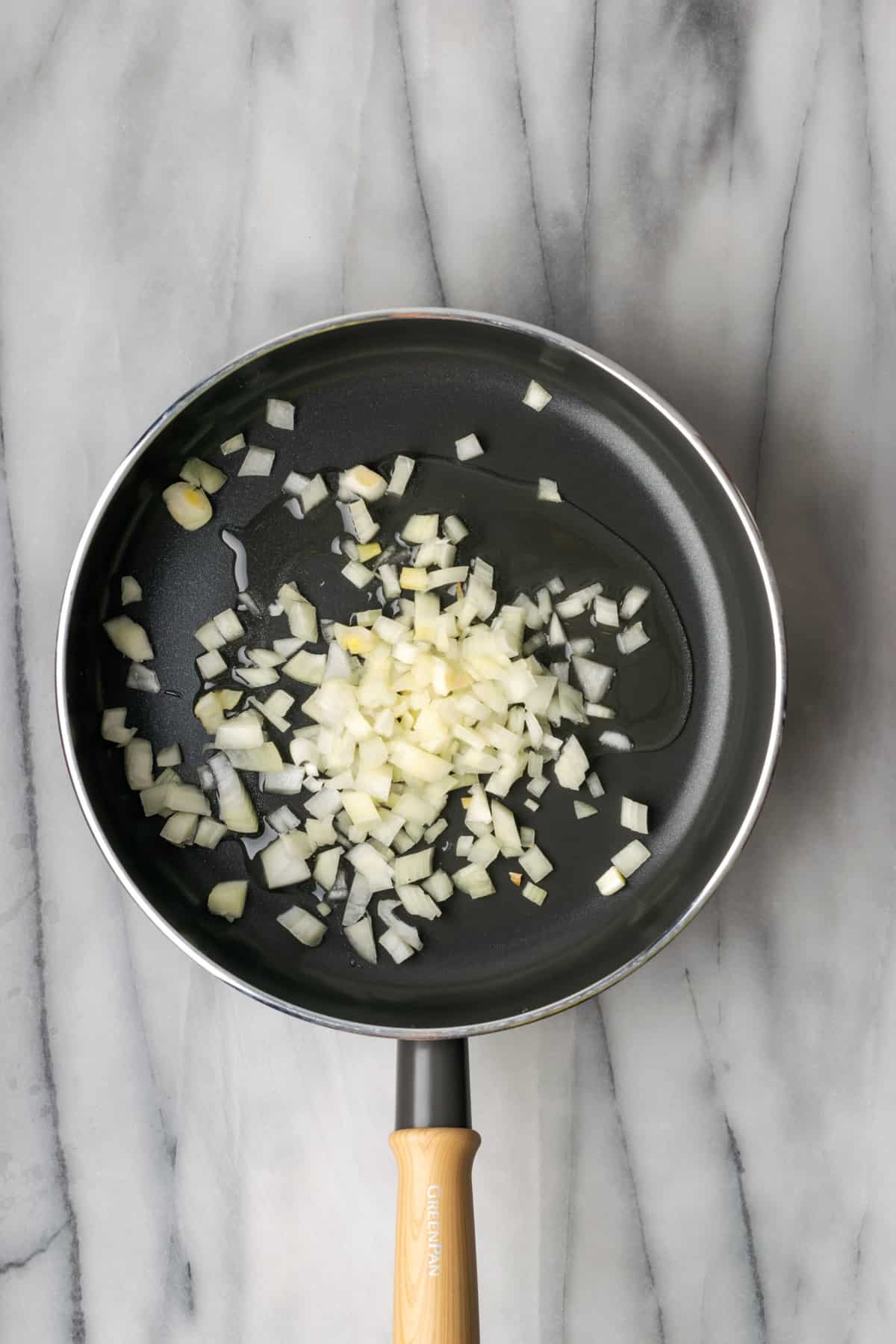 Onions being sauteed in a non stick skillet.